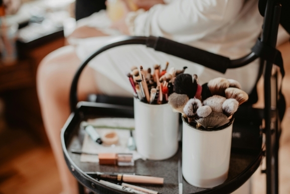 makeup brushes in cups on table